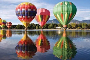 Picture of puzzle art. Hot Air Ballons flying above water.